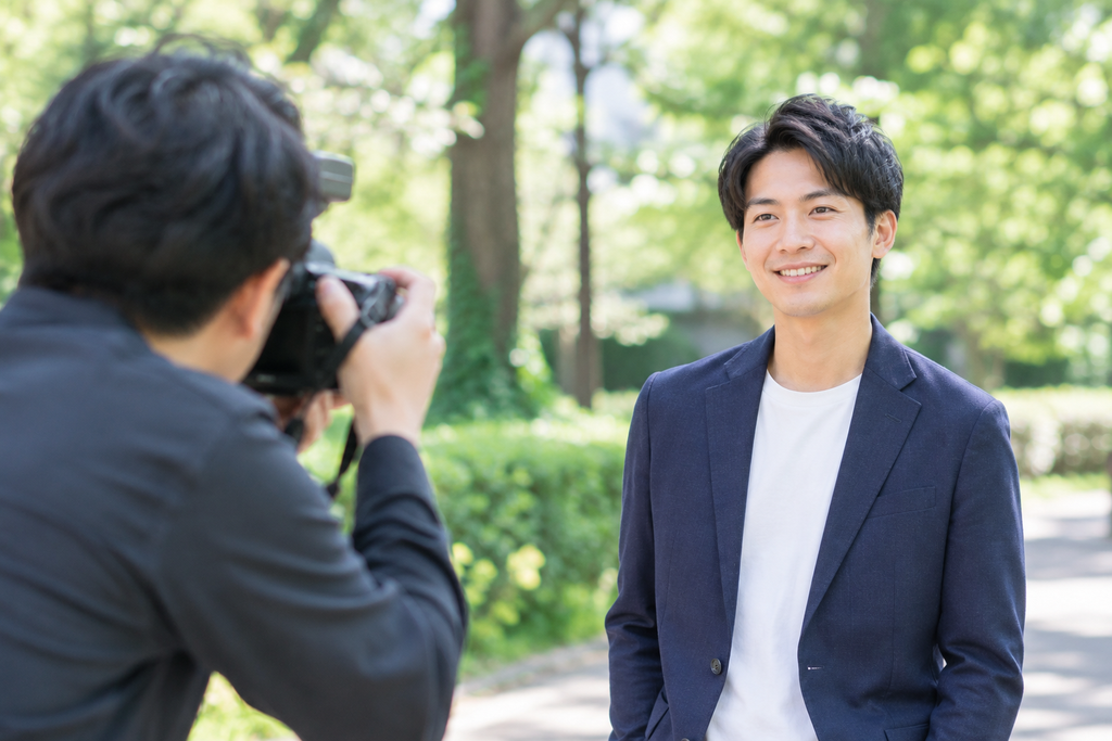 婚活用のプロフィール写真を屋外で撮影する男性とカメラマン